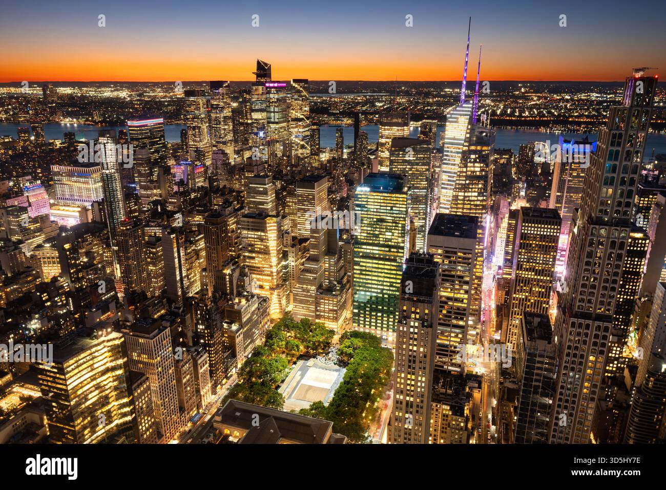 Abendlicher Luftanblick auf die Wolkenkratzer von Midtown Manhattan und den Bryant Park. Beleuchtete Skyline von New York City in der Dämmerung mit Hudson Yards Stockfoto