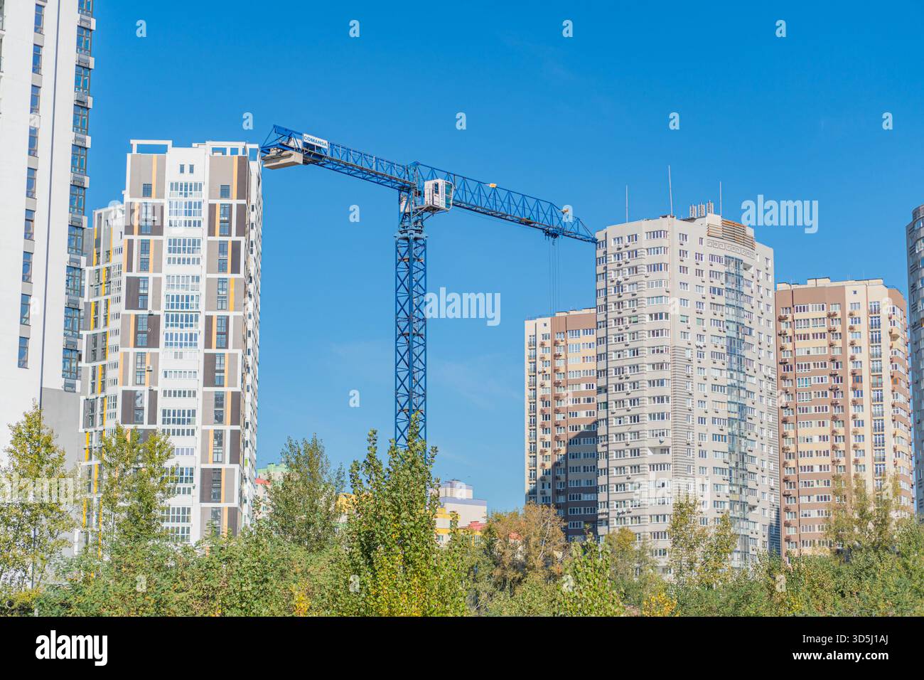 Eine urbane Landschaft voller moderner Hochhäuser, Baukräne und einem Hauch von Natur. Das Bild zeigt die dynamische Entwicklung der Stadt, Stockfoto