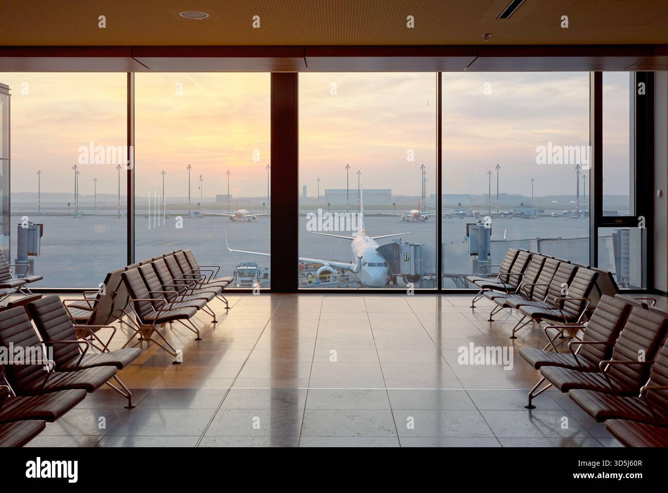 Abflug-Lounge am Flughafen bei Sonnenuntergang, Reisekonzept. Stockfoto
