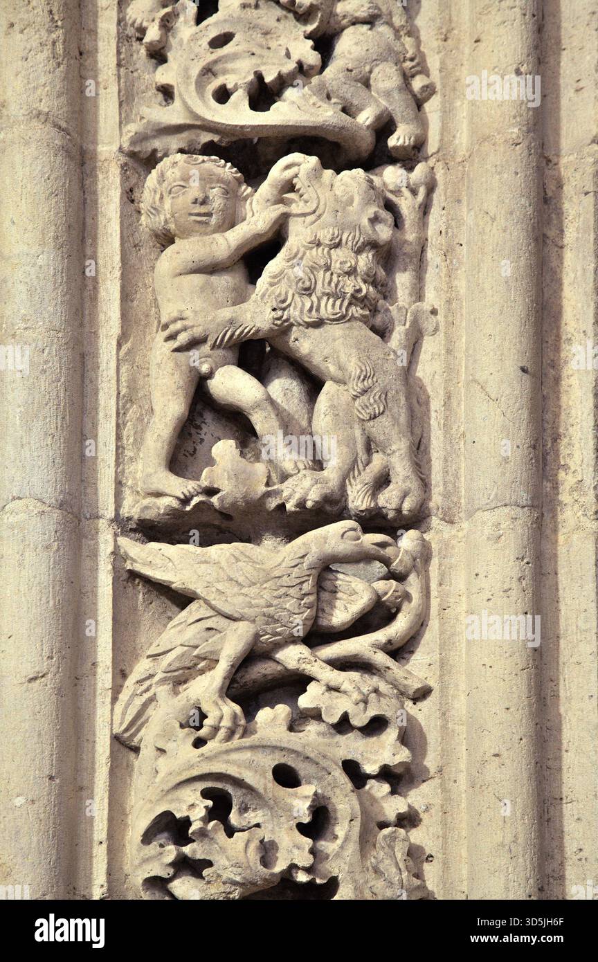 Das Steinrelief zeigt ein Kind, das mit einem Löwen unter einer detaillierten Vogelschnitzerei im Convento de Cristo in Portugal interagiert Stockfoto
