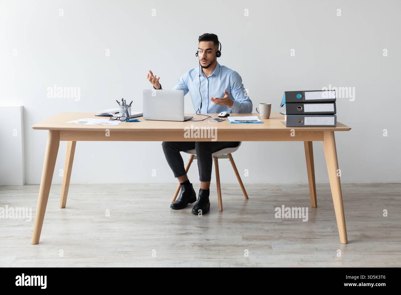 Ein junger arabischer Geschäftsmann führt Videoanrufe im Büro während einer Remote-Arbeitssitzung durch Stockfoto