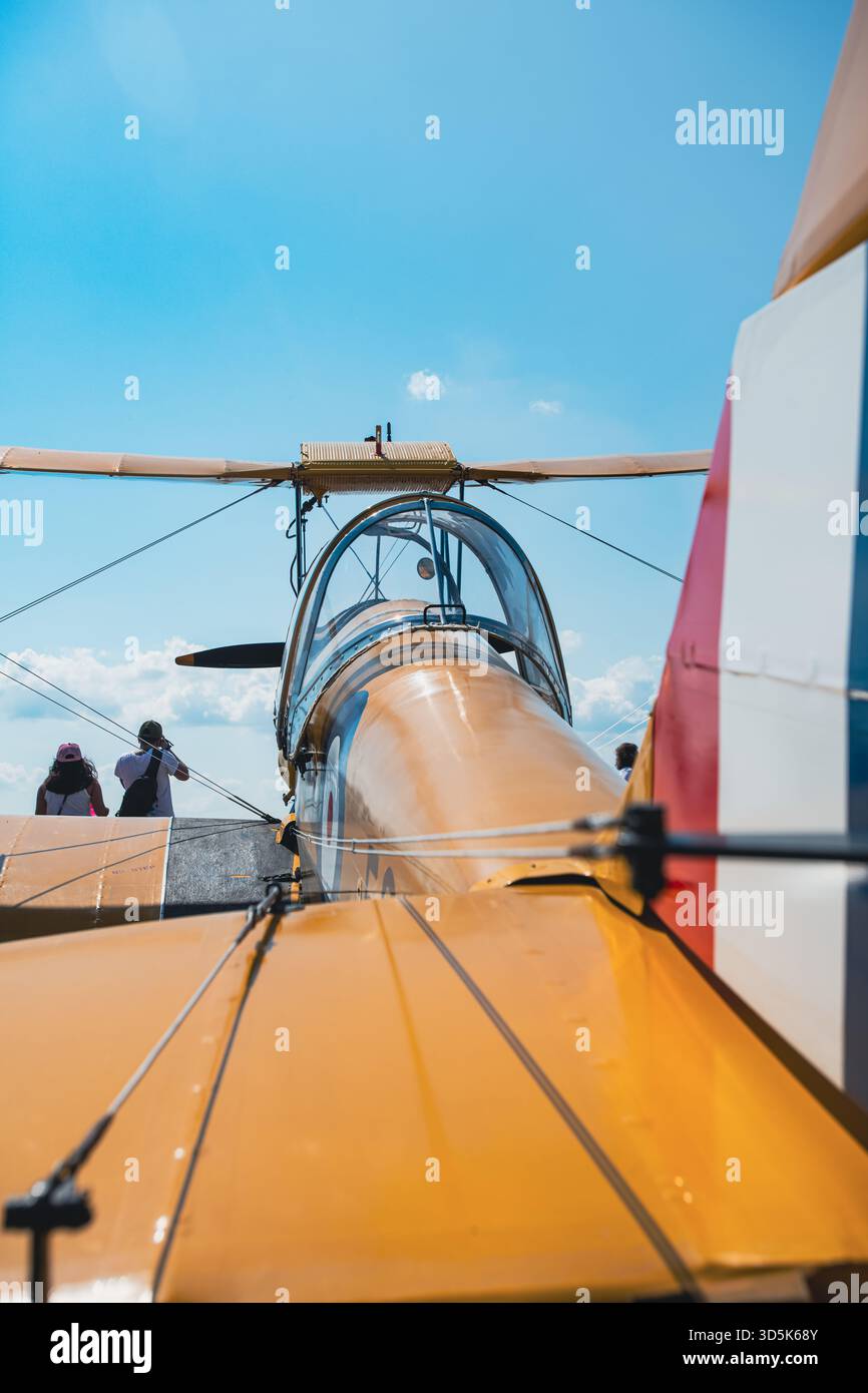 Niedriger Winkel von der Rückseite des altgelben Doppeldeckers mit offenem Cockpit, Rumpf, oberem Flügel und Rotorblättern. Schuss von hinten auf dem Pilotensitz Stockfoto