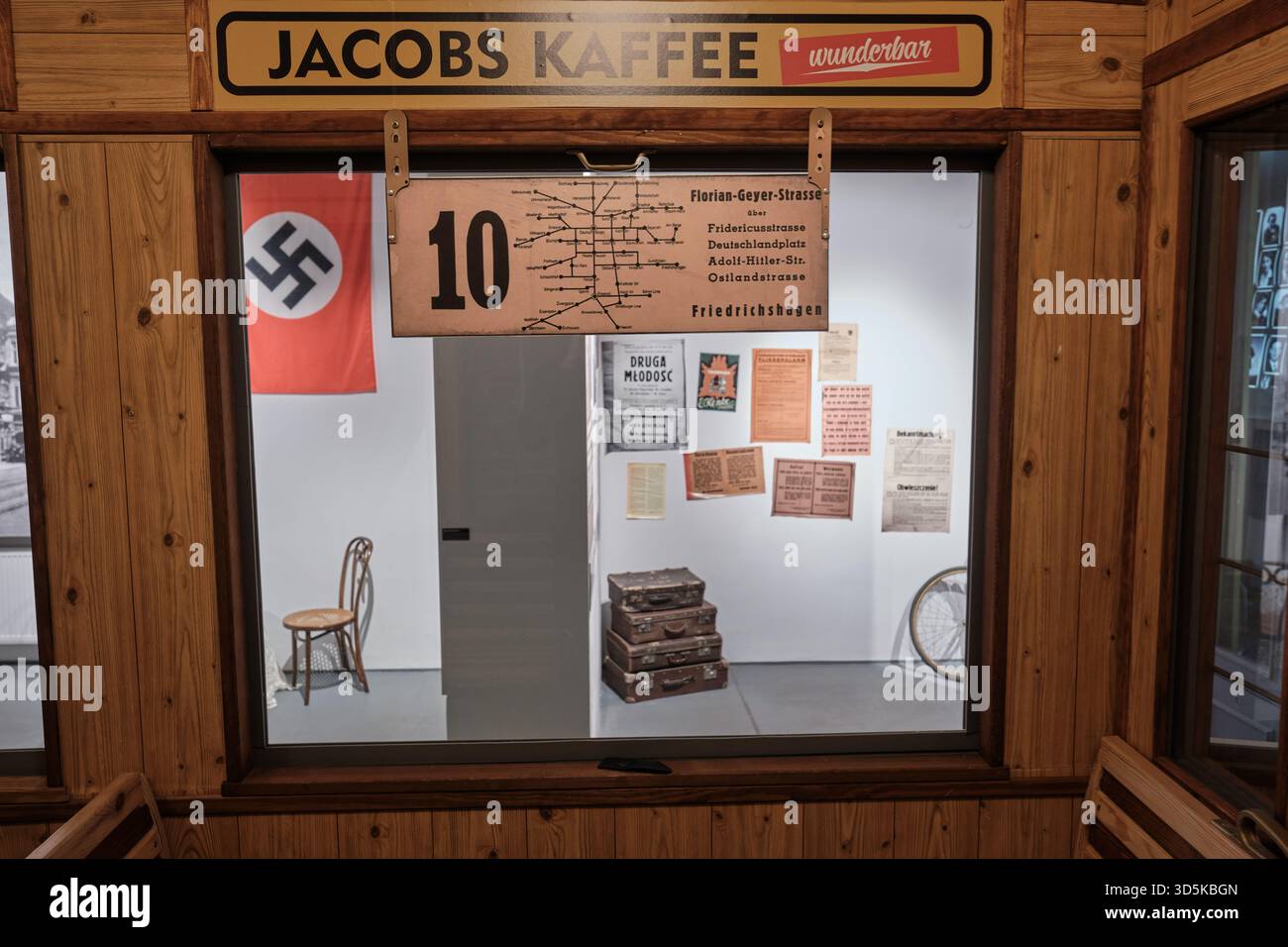 Lodz, Polen - 15. November 2025: Blick vom Straßenbahnfenster auf Nazi-Flagge, Plakate und Koffer in der Ausstellung Museum of Unabhängigkeitstraditionen über Besatzung und Deportation. Stockfoto
