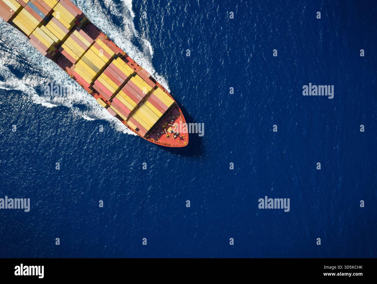 Hohe Luftaufnahme eines großen Industriecontainer-Frachtschiffs, das über den Ozean mit Kopierraum segelt Stockfoto