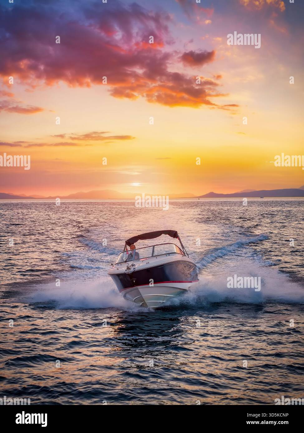 Vorderansicht eines Motorschnellbootes, das während des goldenen Sonnenuntergangs im Sommer über das Meer fährt Stockfoto