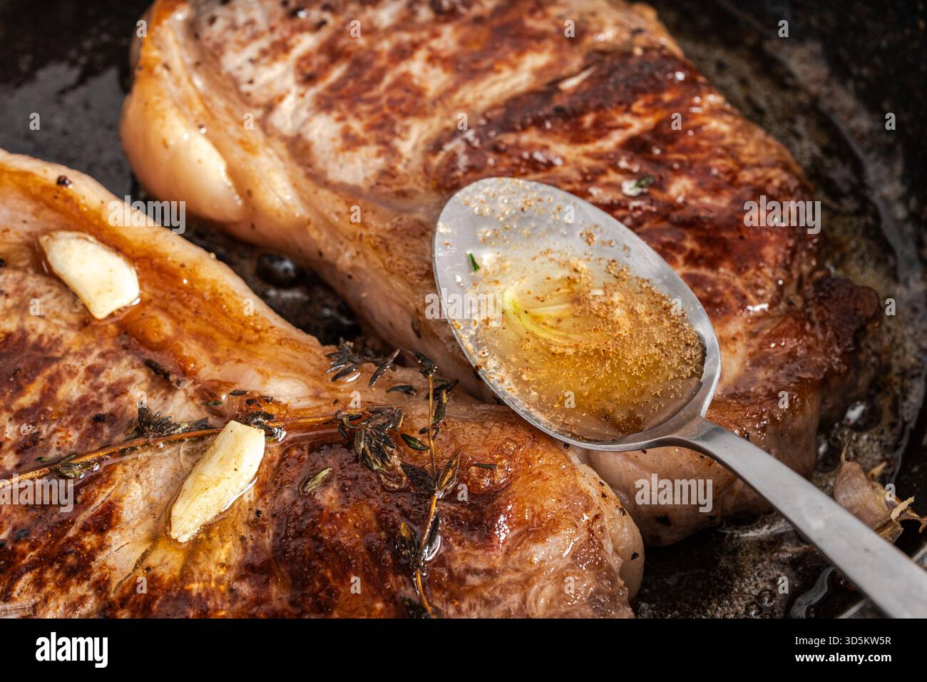 Rindersteaks werden in der Pfanne gebraten und mit eigenen Säften und Sauce garniert. Hochwertige Fotos Stockfoto