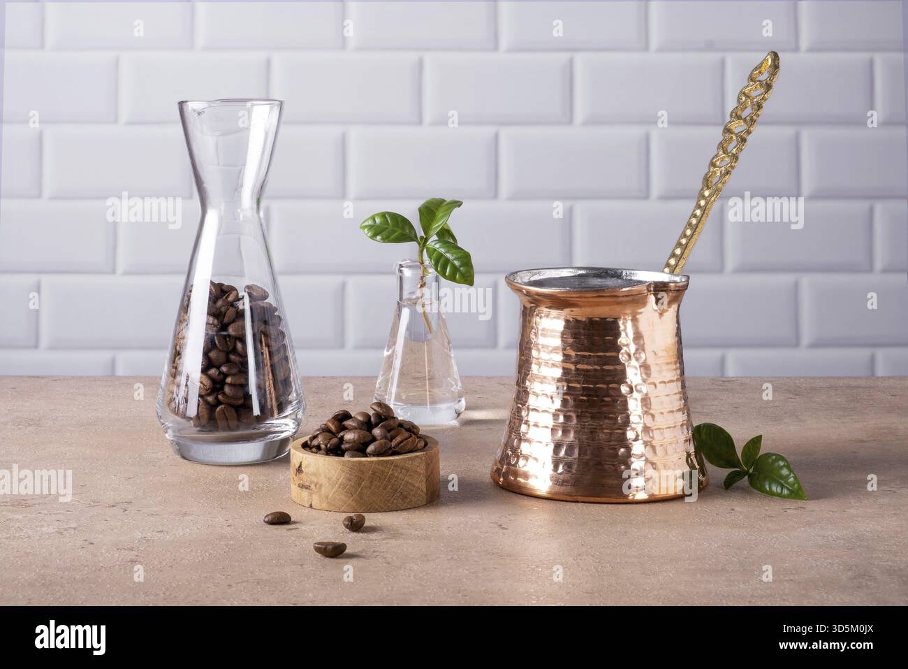 Zusammensetzung einer traditionellen türkischen Kaffeekanne, Kaffeebohnen und einem Zweig eines Kaffeebaumes. Selektiver Fokus Stockfoto