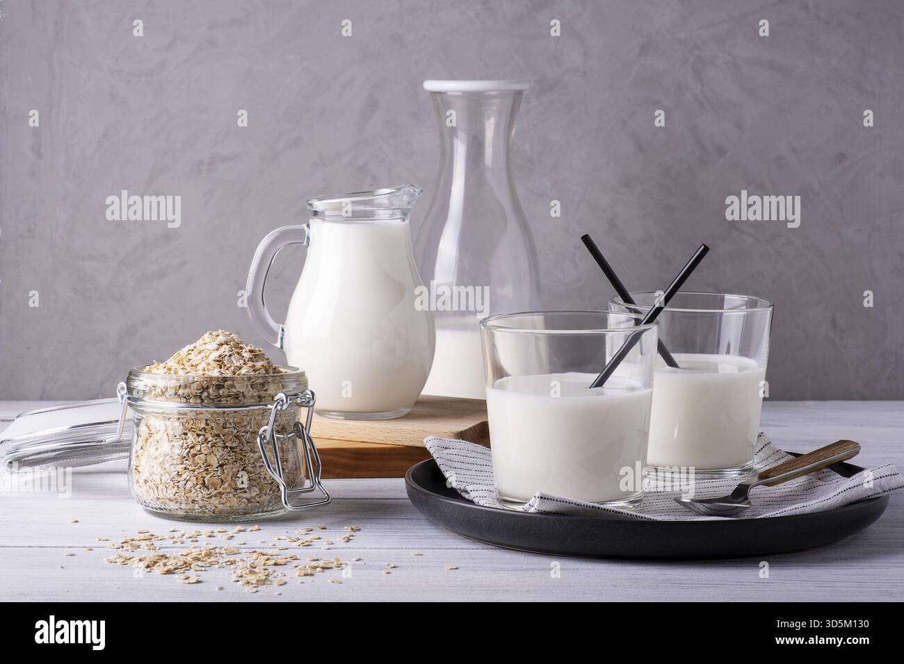 Zusammensetzung verschiedener Glasserviergefäße mit Hafermilch- und Hafermehlbehältern. Alternative zu laktosefreier Milch. Gesunde und diätetische Lebensmittel. Auswahl Stockfoto