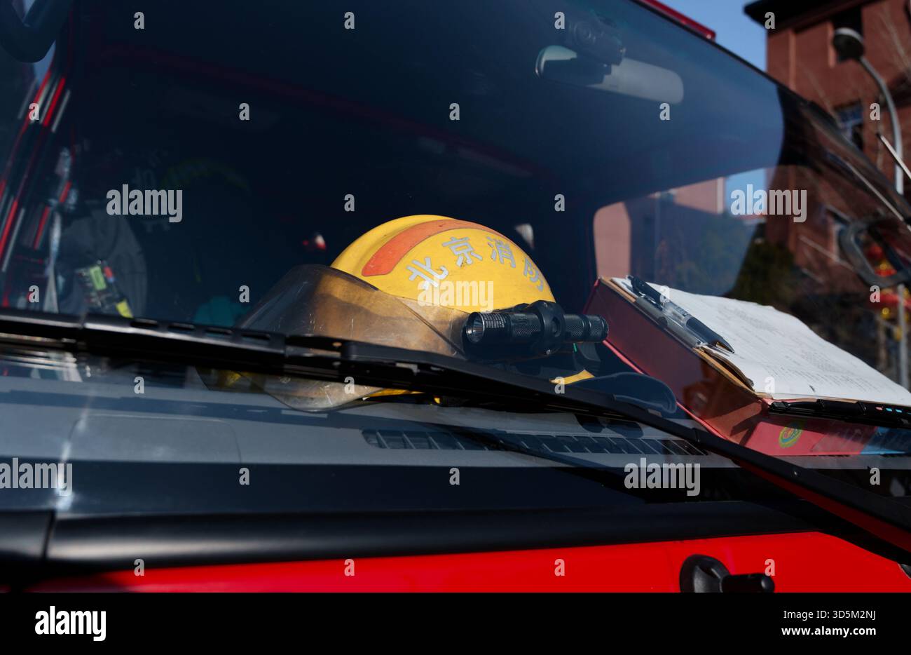 Feuerwehrhelm und Klemmbrett in einem Rettungswagen-Fahrerhaus, durch die Windschutzscheibe gesehen Stockfoto