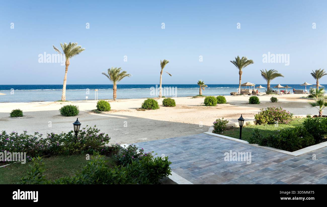 Der Blick von einem Hotel-Chalet überblickt den Strand des Roten Meeres und zeigt die sandige Küste, das ruhige Wasser und die ruhige Küstenatmosphäre. Stockfoto