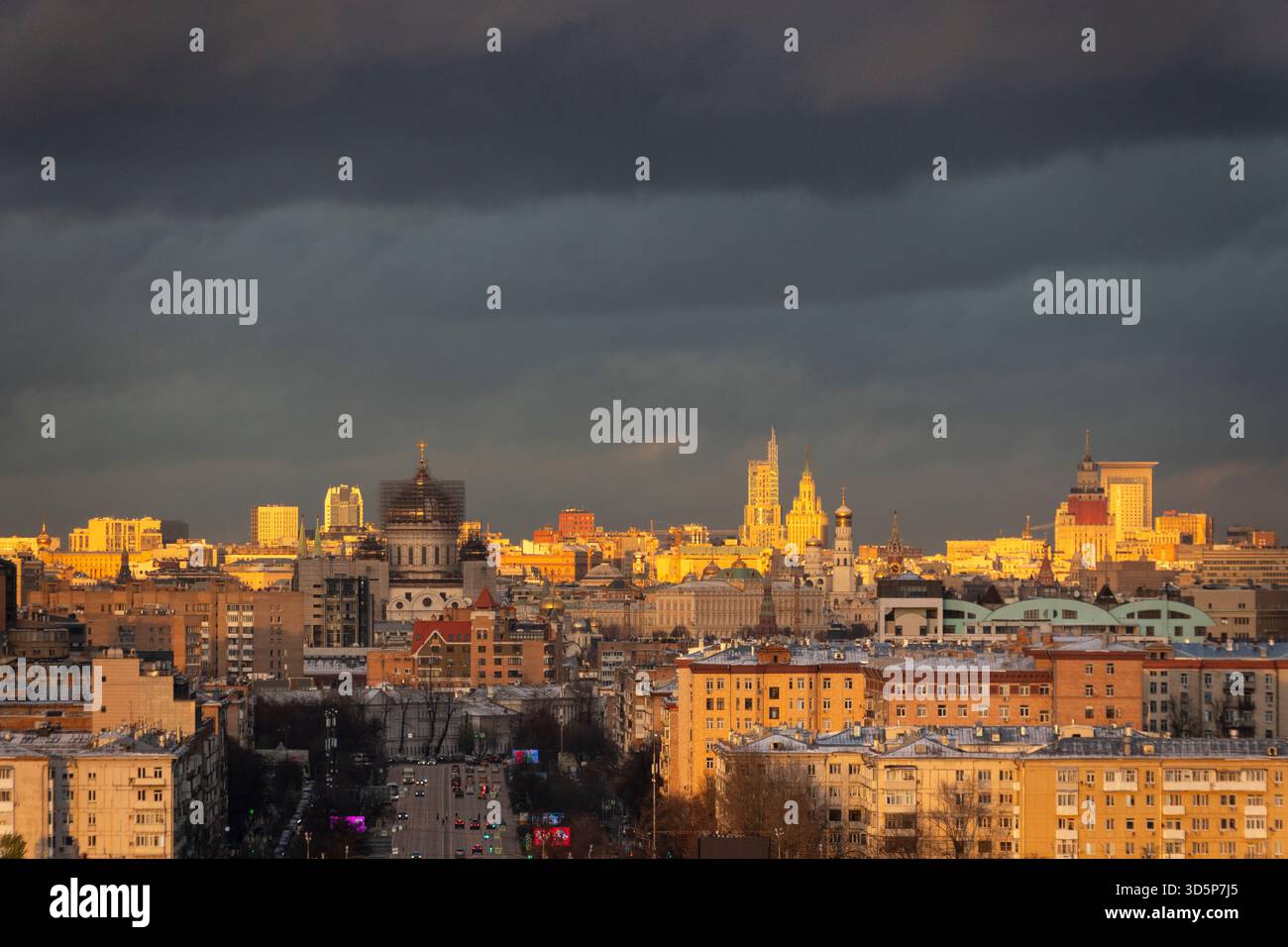 Eine Skyline der Stadt mit bewölktem Himmel im Hintergrund in Moskau, Russland. Die Stadt wird durch den Sonnenuntergang beleuchtet, was eine warme und einladende Atmosphäre schafft Stockfoto