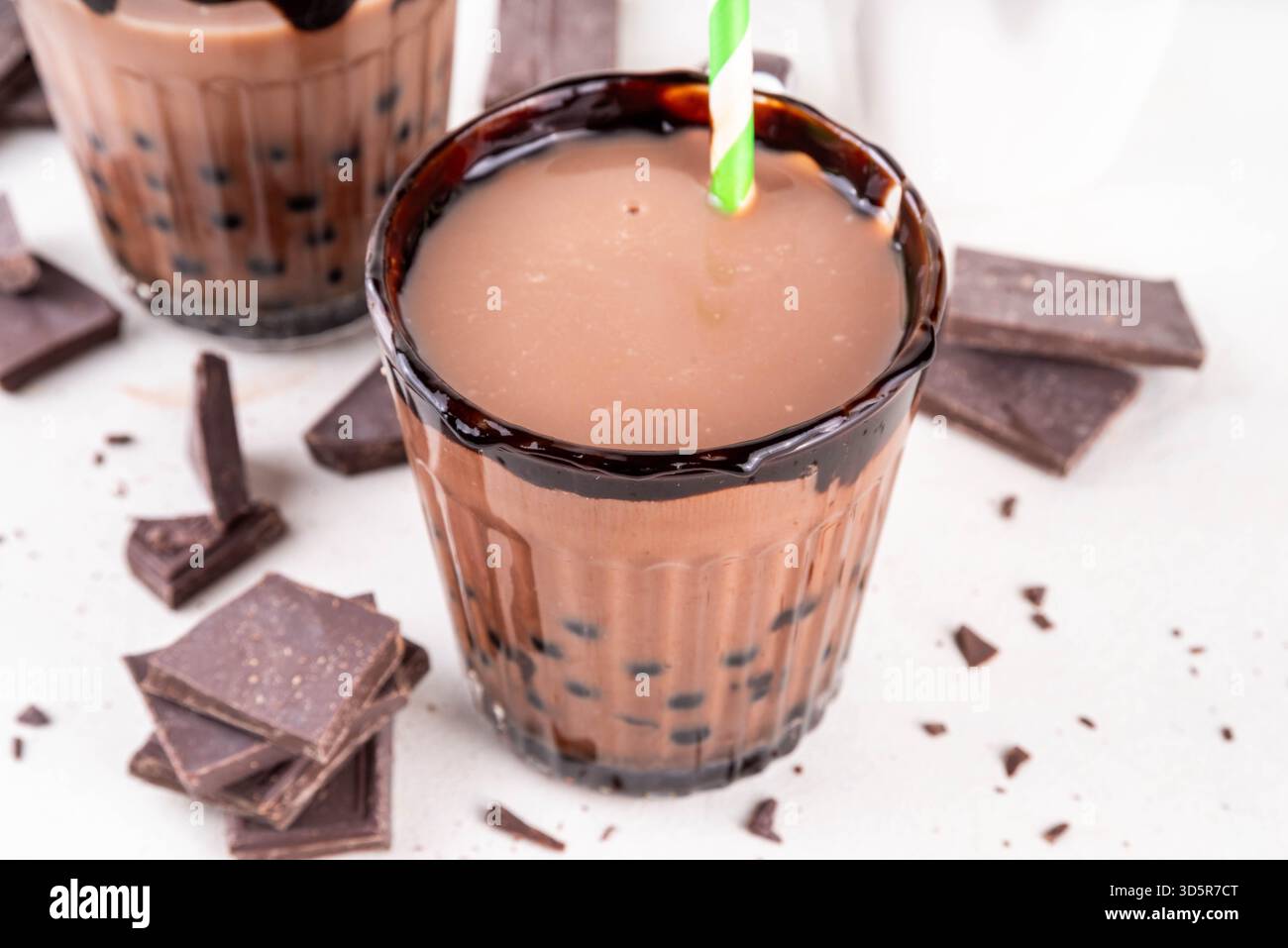 Leckerer heißer Schokoladen-Bubble-Tee. Kakao warm- oder kaltgetränk mit Tapiokakugeln und dunklem Schokoladensirup, süßes Dessertgetränk auf weißem Tisch mit c Stockfoto