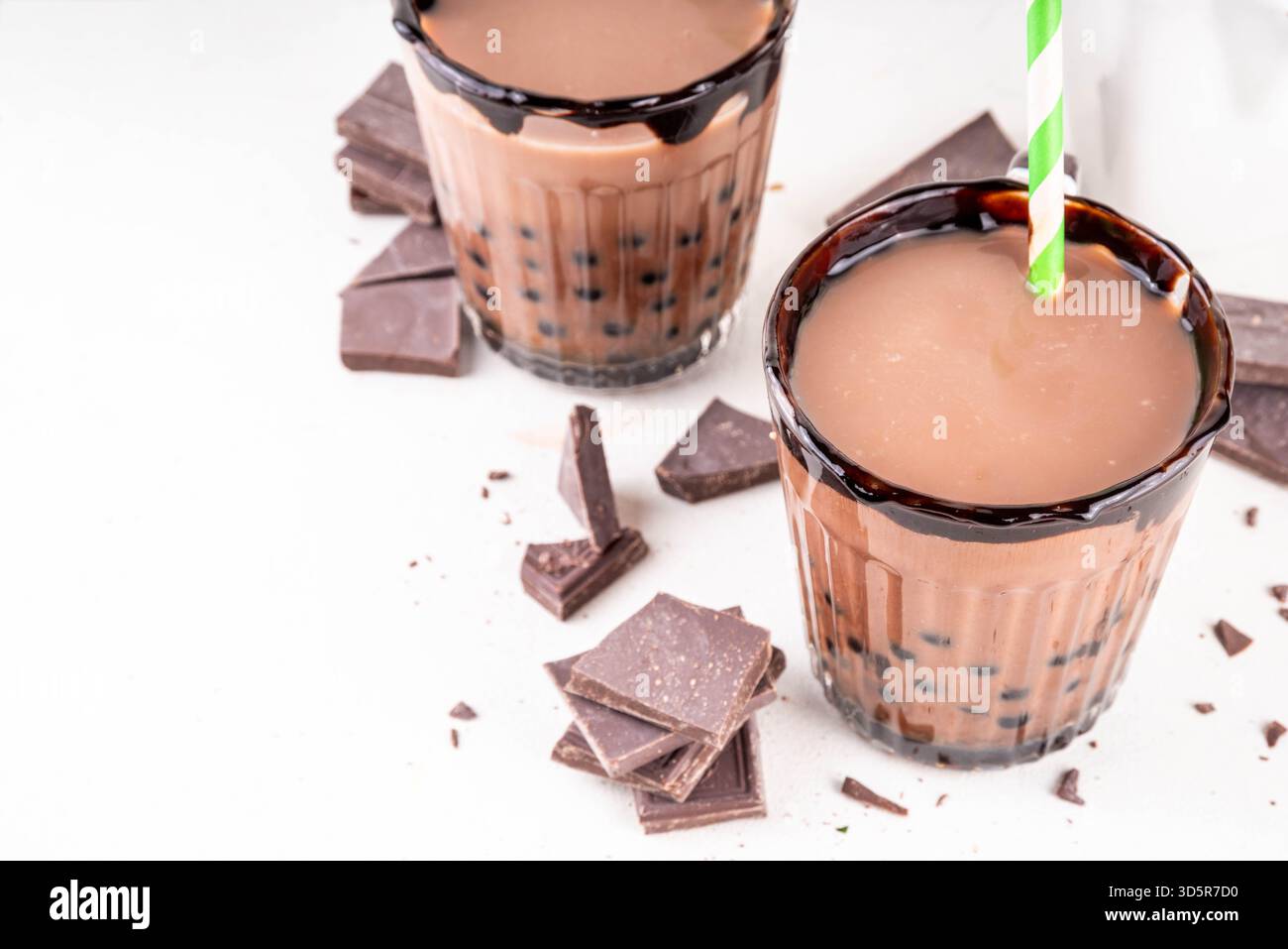 Leckerer heißer Schokoladen-Bubble-Tee. Kakao warm- oder kaltgetränk mit Tapiokakugeln und dunklem Schokoladensirup, süßes Dessertgetränk auf weißem Tisch mit c Stockfoto