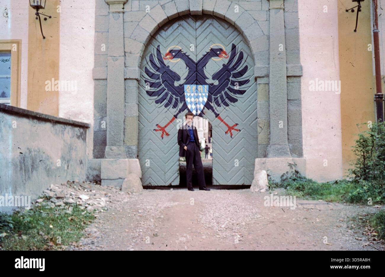 Ein Junge steht vor einem Tor zur Abtei Ettal. [Automatisierte Übersetzung] Stockfoto