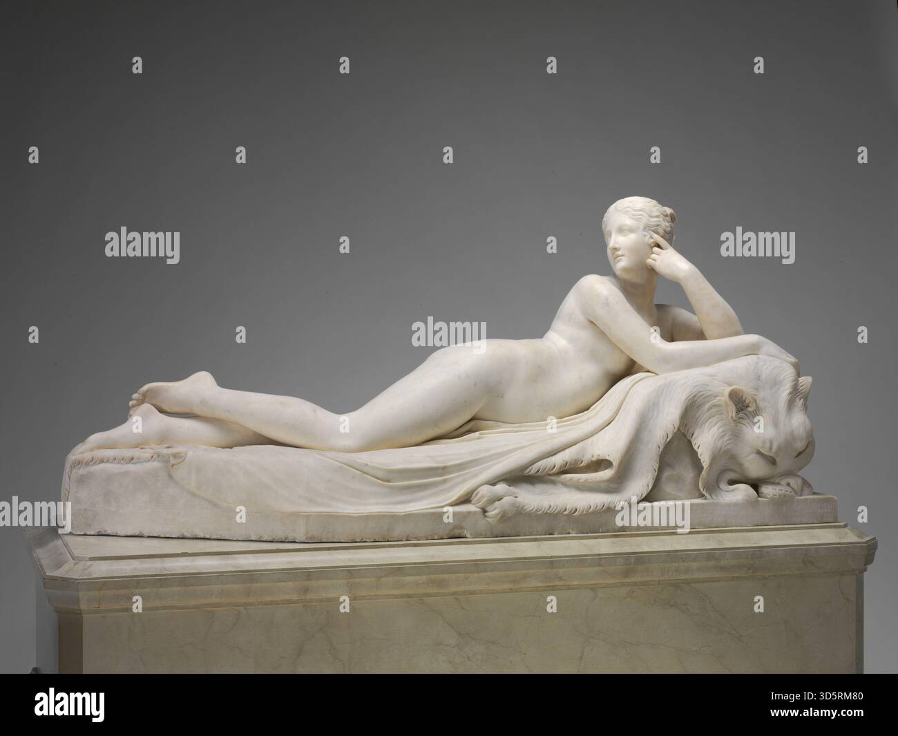 Diese Marmorskulptur von Antonio Canova zeigt eine Naiade, die eine weibliche Wassernymphe mit fließenden Haaren, zart drapierten, anmutigen Posen, naturalistischer Anatomie, ausgewogener Komposition, ausdrucksstarke Geste, die 1820-1823 aus einem Modell von 1815–1817 geschnitzt wurde und die neoklassizistische italienische Bildhauertechnik, die Aufmerksamkeit auf Proportionen und die lebensechte Darstellung auf einer Basis veranschaulicht. Stockfoto