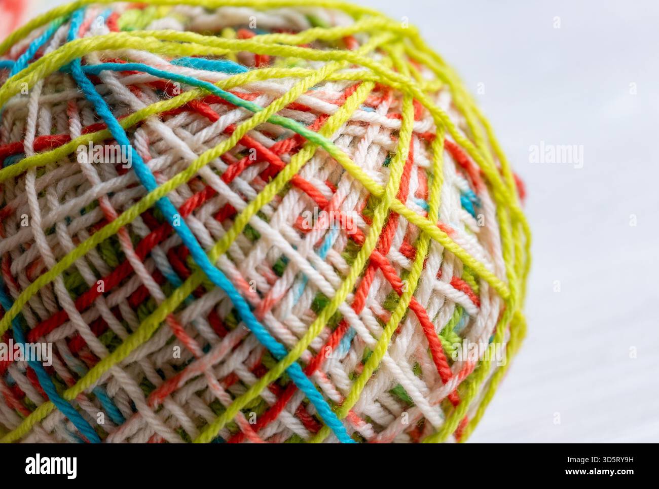 Farbenfrohes Wollgarn in Nahaufnahme, das weiche Fasern, Textur und leuchtende Farben hervorhebt, ideal für Themen rund um Stricken, Kunsthandwerk und Textilien Stockfoto