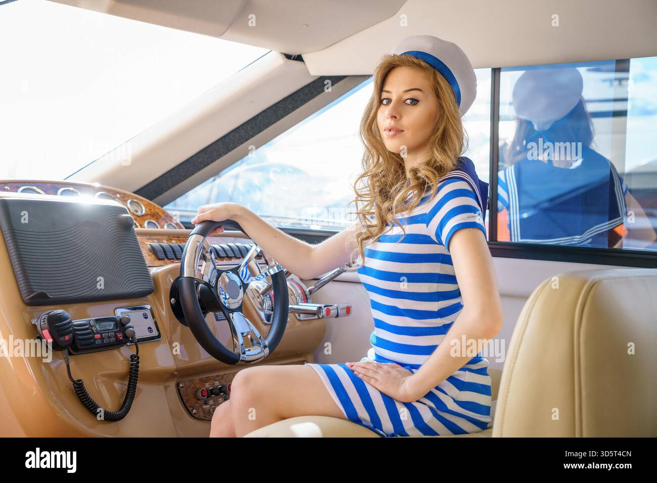 Schönes Segelmädchen auf einer Yacht am Steuer || Model veröffentlicht Stockfoto
