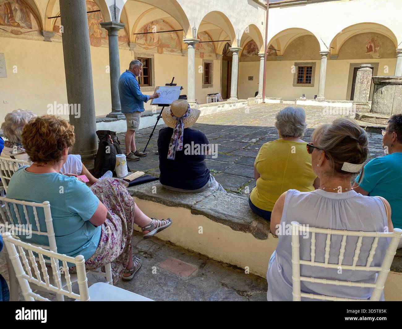 Ein Aquarellkünstler mit einer kleinen Gruppe von Kunststudenten in den umliegenden Kreuzgängen im Innenhof des restaurierten Convento del Carmine in der Nähe von t - Smartphone-aufgenommenes Stockfoto