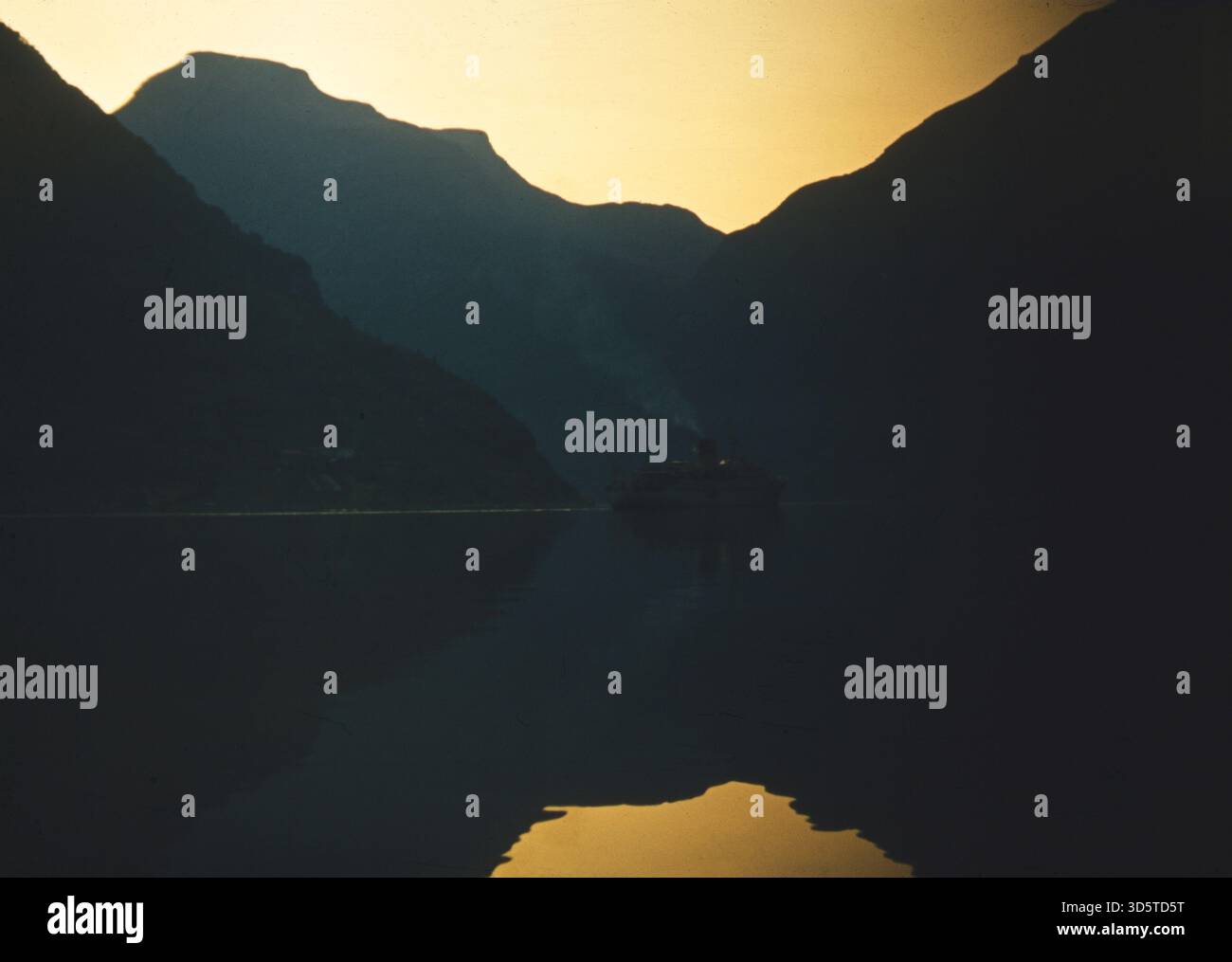 Untergehende Sonne und reflektierende Berge am Geirangerfjord in Norwegen. [Automatisierte Übersetzung] Stockfoto