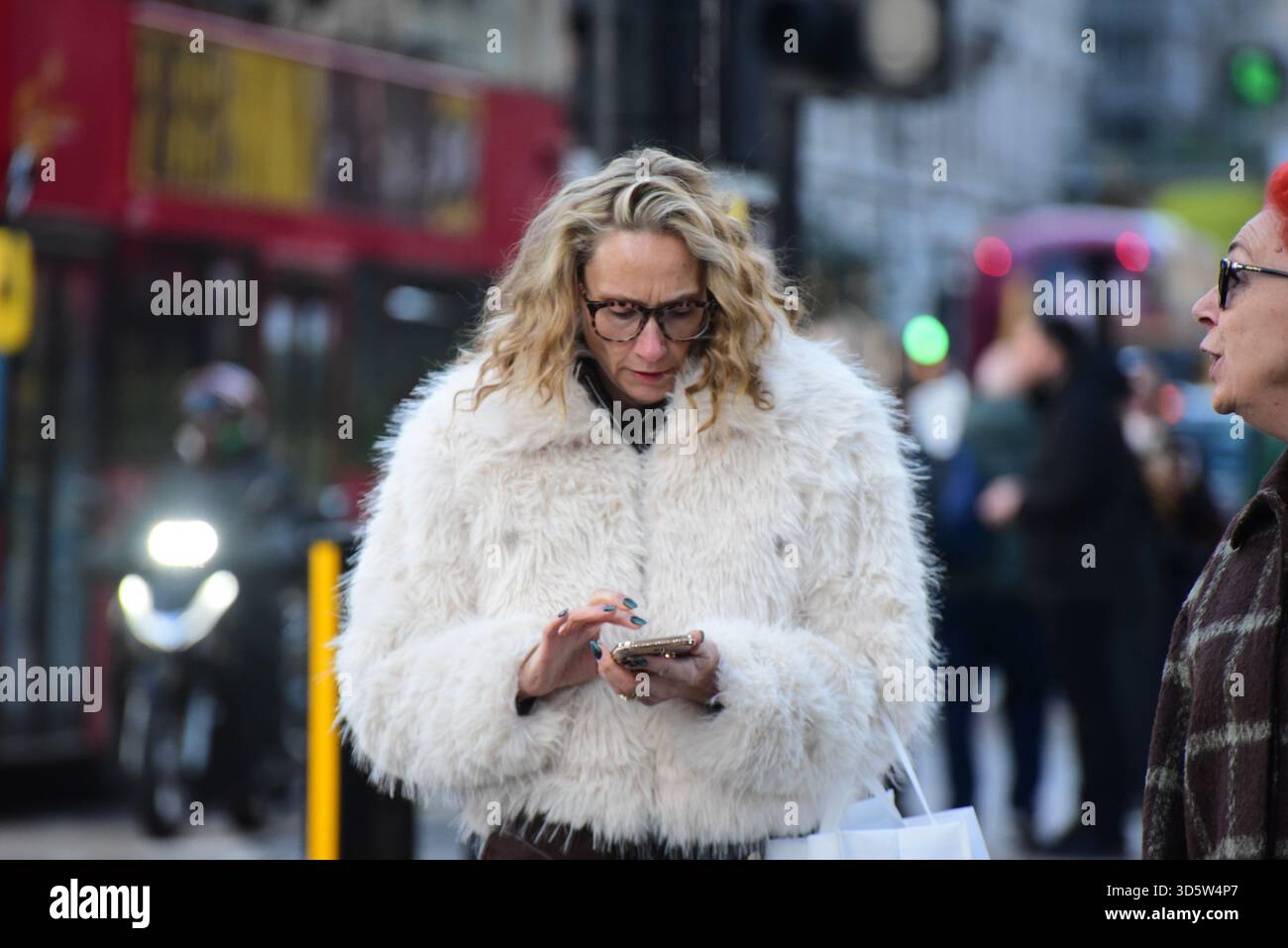 London, Großbritannien. 17. November 2025: Eine Dame mit einem weißen flauschigen Mantel am 17. november 25 Credit: graham mitchell/Alamy Live News Stockfoto