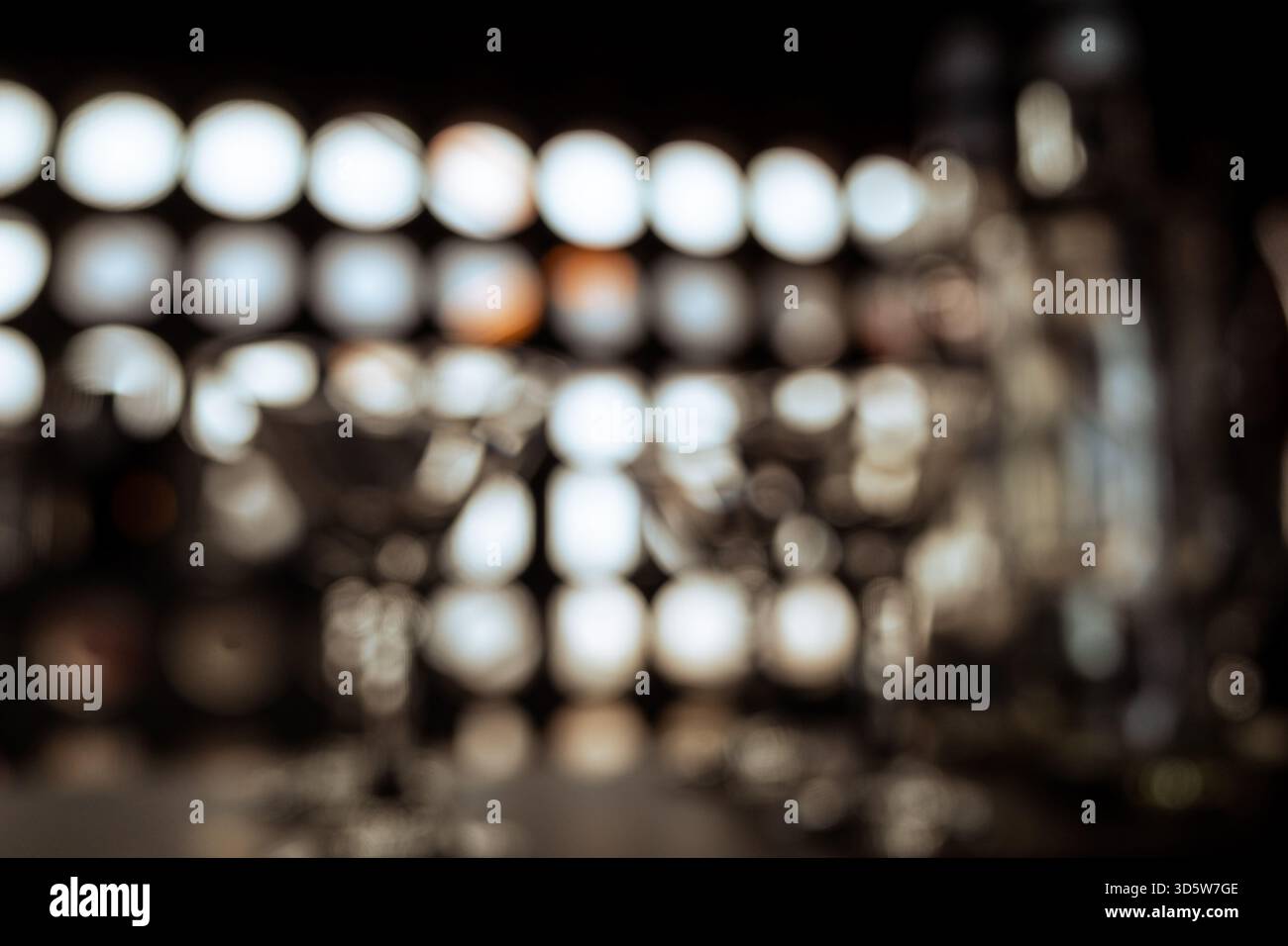 Verschwommenes Bild von Gläsern und Flaschen, das auf dem Regal eines Cafés für Schatten und Licht angezeigt wird Stockfoto