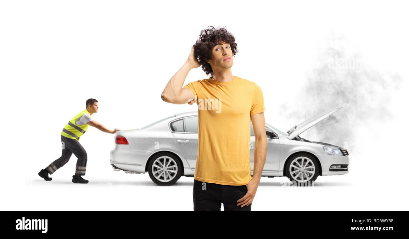 Nachdenklicher junger Mann mit einem nicht funktionierenden Auto, das auf Hilfe am Straßenrand wartet, isoliert auf blauem Hintergrund Stockfoto