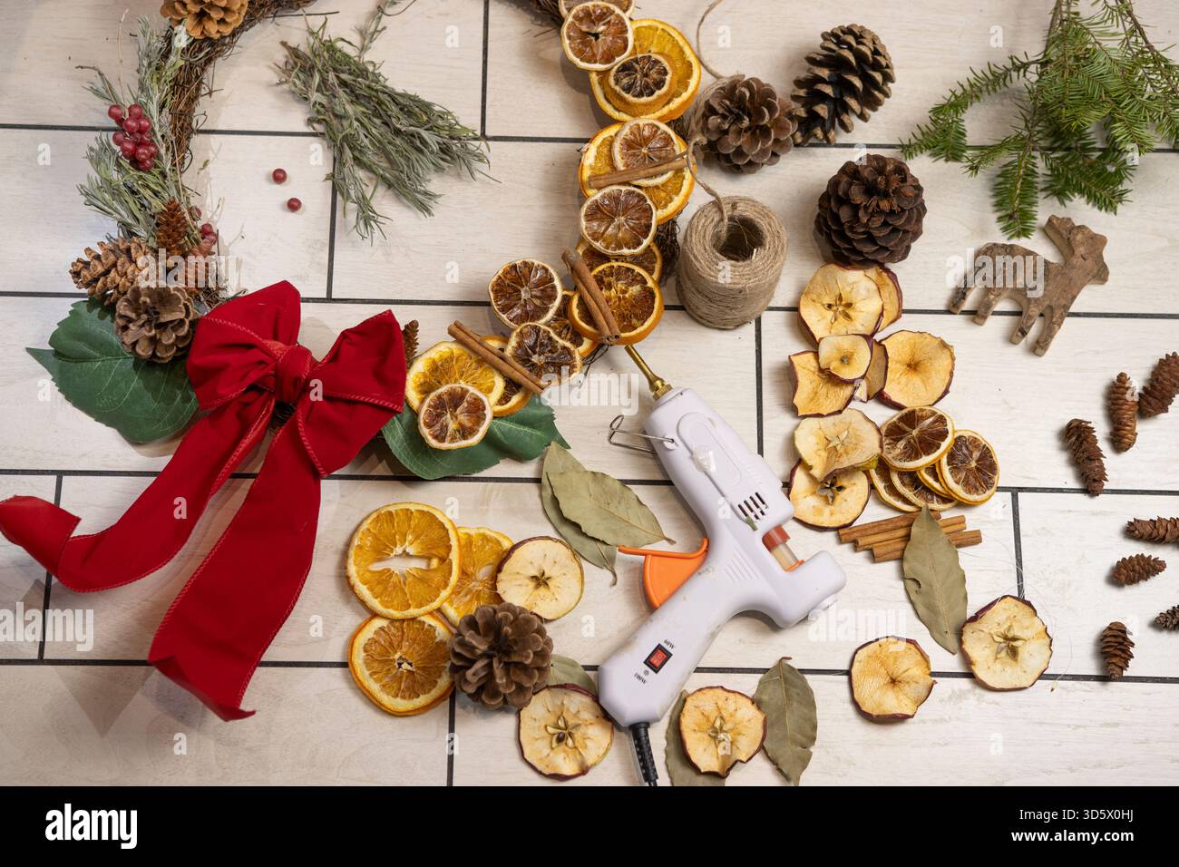 Rustikale Weihnachtsflachlage mit getrockneten Orangenscheiben, Tannenzapfen und natürlichen Dekorationen Stockfoto
