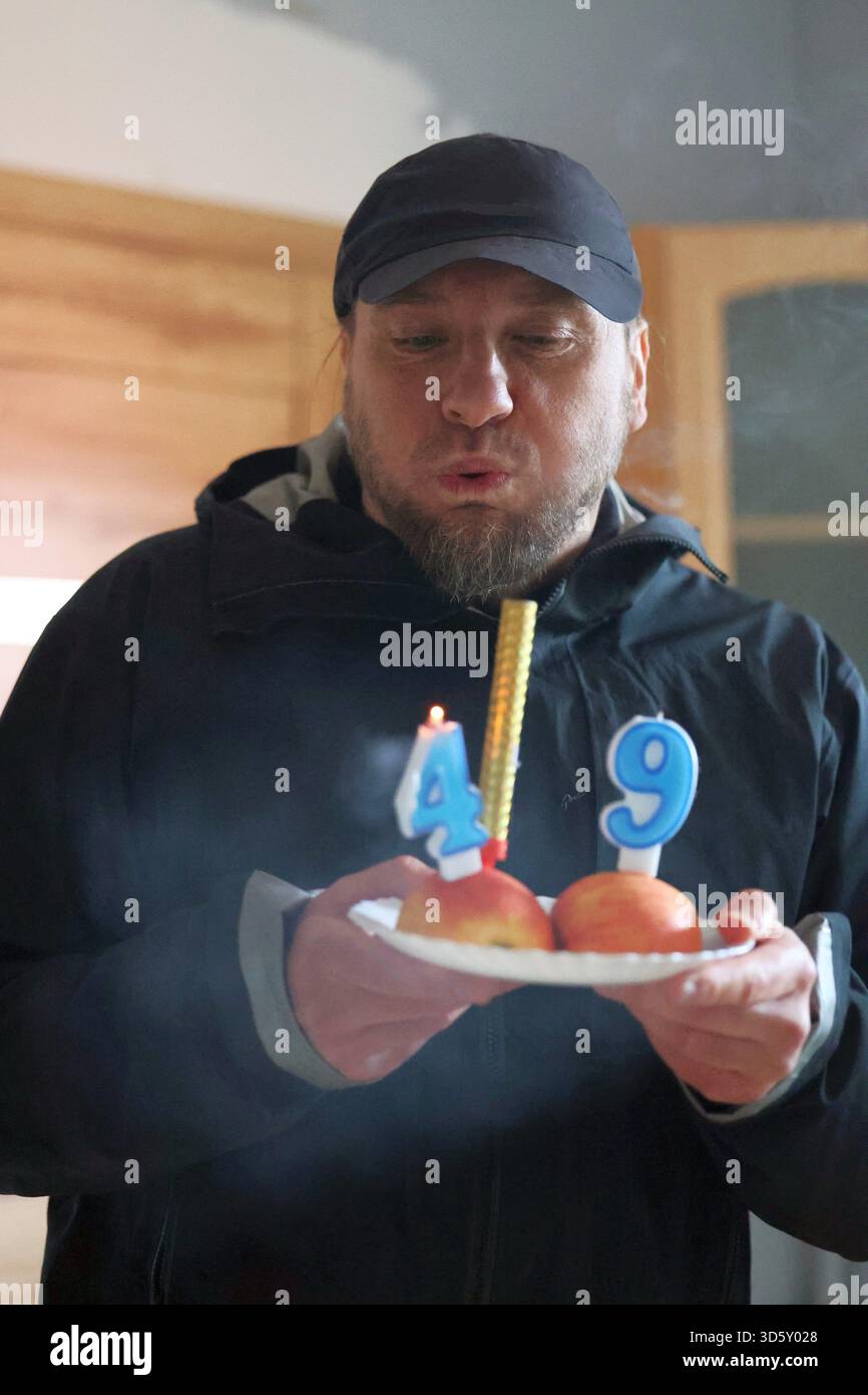 Mann, der Kerzen ausbläst, an seinem 49. Geburtstag Stockfoto
