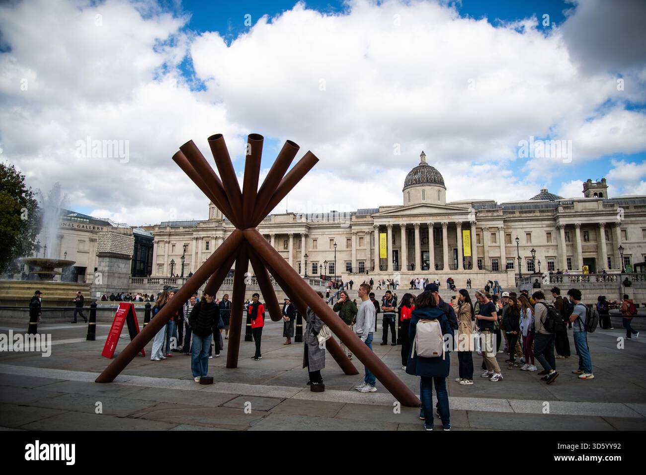 Verwitterte Stahlrohrskulptur von Paul Cocksedge am Trafalgar Square London, die sich an Nelson’s Column orientiert, fängt das Stadtbild und das Zeitreisekonzept ein Stockfoto
