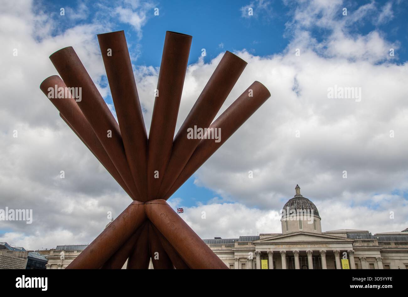 Verwitterte Stahlrohrskulptur von Paul Cocksedge am Trafalgar Square London, die sich an Nelson’s Column orientiert, fängt das Stadtbild und das Zeitreisekonzept ein Stockfoto