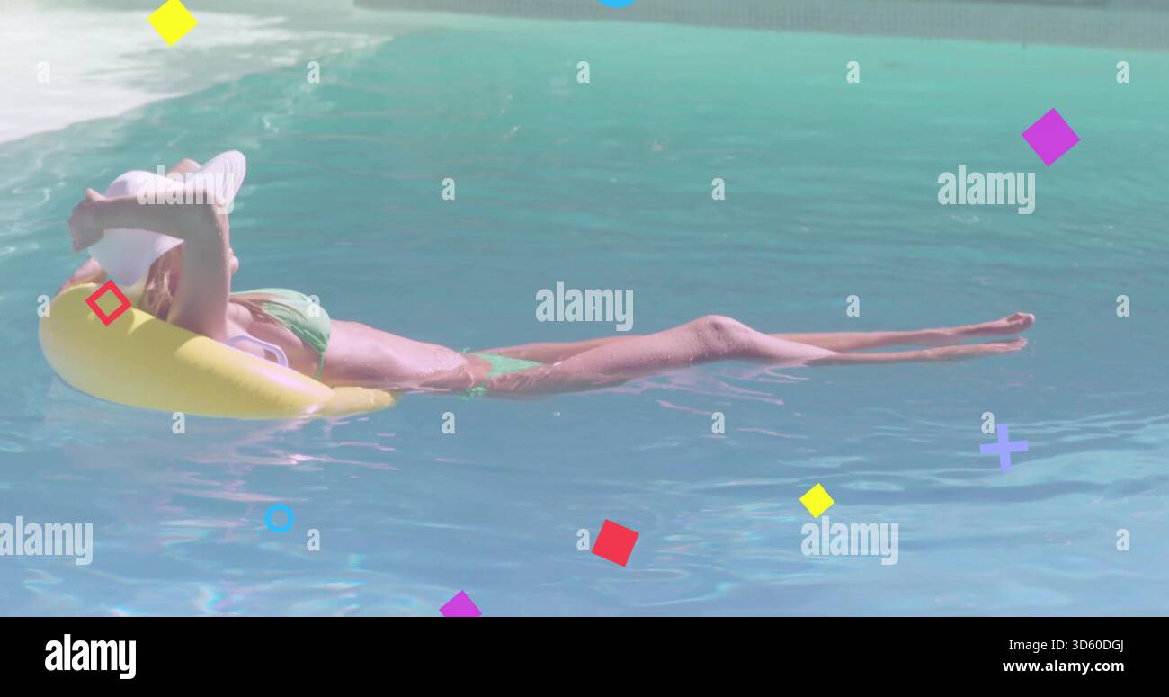 Liegende Frau in grünem Bikini, weißer breiter Hut, schwimmend auf gelbem Ring im Pool mit Überzügen Stockfoto