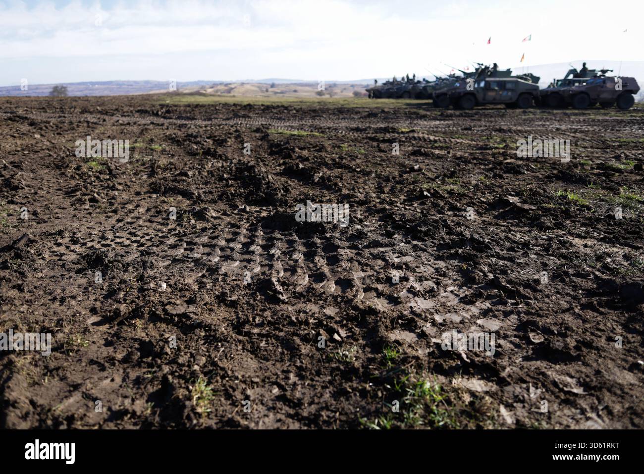 Details mit gepanzerten Fahrzeugspuren im Schmutz während einer multinationalen NATO-Übung. Stockfoto
