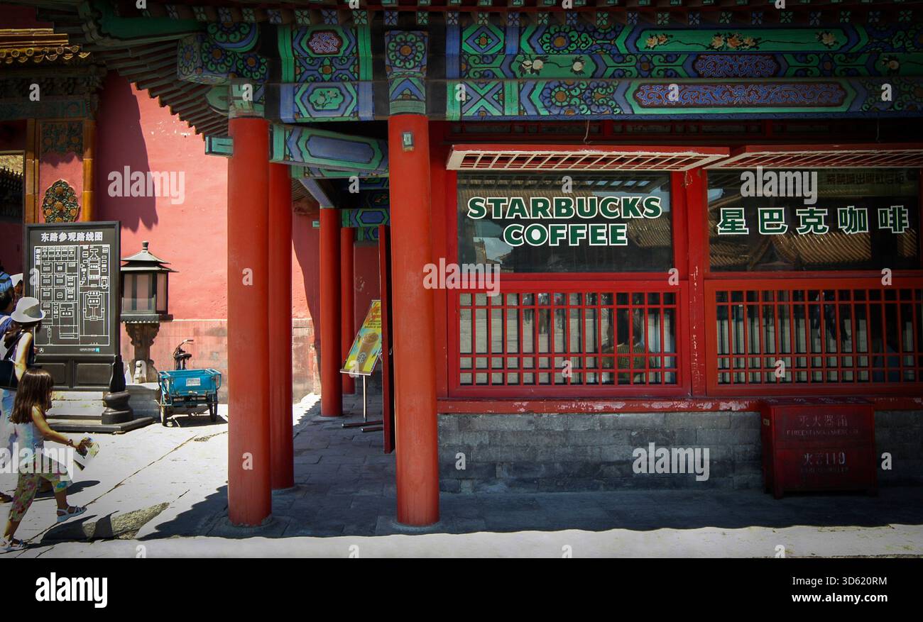 Verbotene Stadt, Starbucks Kaffee, Peking, China. Juli 2004. Westliche Touristen gehen in den Starbucks Coffee Shop in der Nähe der Hall of Conservving Harmony in der Verbotenen Stadt in der chinesischen Hauptstadt Peking. Der kleine Coffee Shop wurde 2000 eröffnet und 2007 geschlossen, nachdem Proteste, dass er unangemessen sei oder die historische Kulturstätte beschädigte. 2007 nannte Howard Schultz, damals Chairman der Starbucks Corp. China den größten Wachstumsmarkt des Unternehmens. Stockfoto