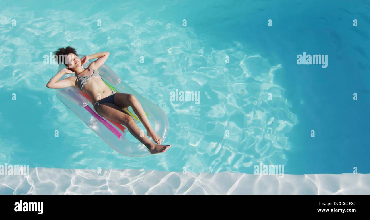 Schwimmende Frau mit zweiteiligem Badeanzug auf transparenter aufblasbarer Liege im Pool, Kopierraum Stockfoto