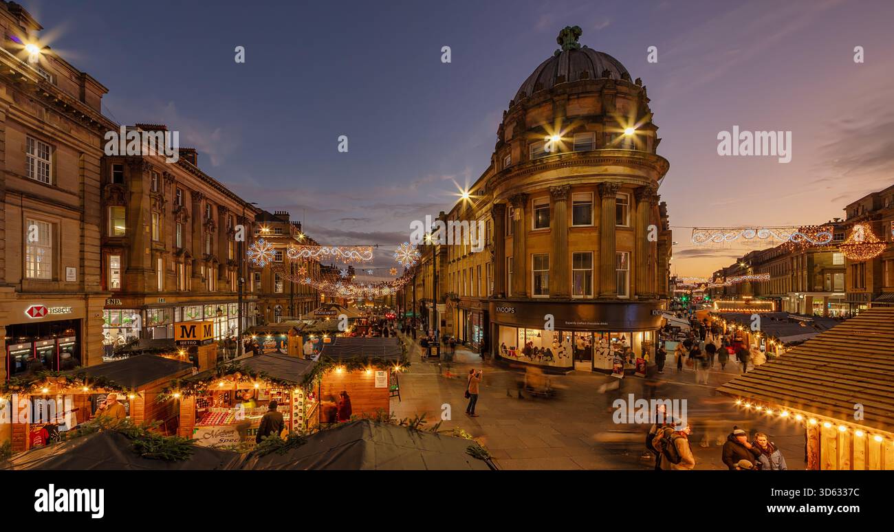 Ein Blick auf die Dämmerung des Weihnachtsmarktes in Newcastle upon Tyne am Grey's Monument mit Blick auf die Grey Street mit Weihnachtsständen und Beleuchtung Stockfoto
