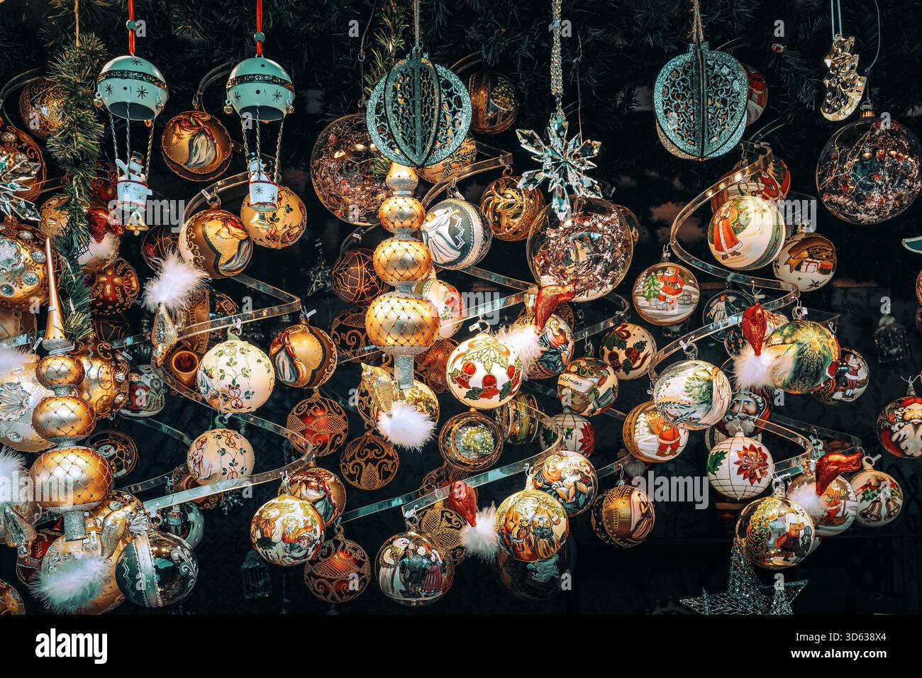 Eine kunstvolle und festliche Sammlung handbemalter und glitzernder Weihnachtskugeln hängt an einer Ständerdecke auf dem Wiener Weihnachtsmarkt. Stockfoto