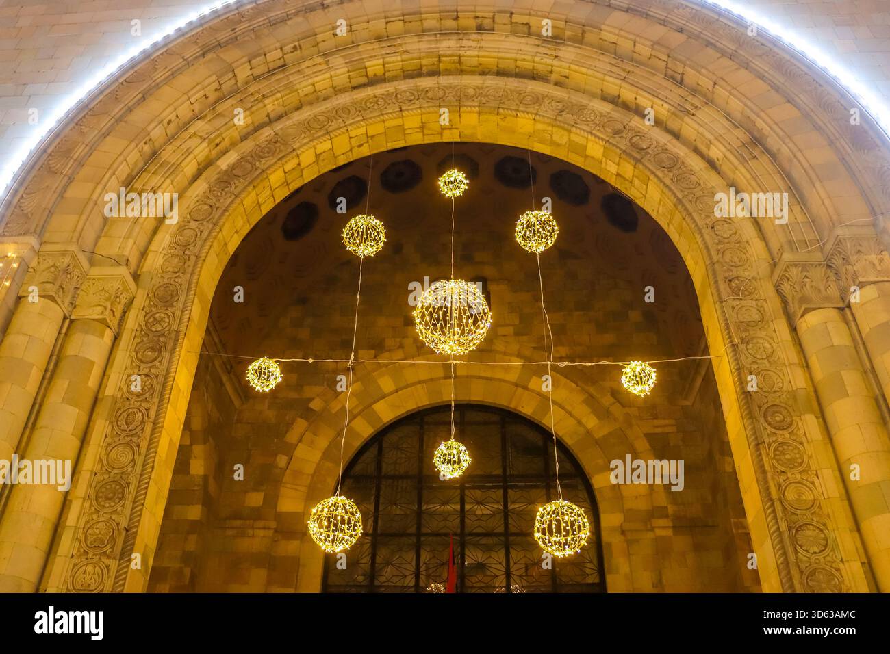 jerewan, ArmeniaEin abendliche Szene mit einem architektonischen Bogen, der mit Silvesterlichtern und leuchtenden Kugeln dekoriert ist. Stockfoto