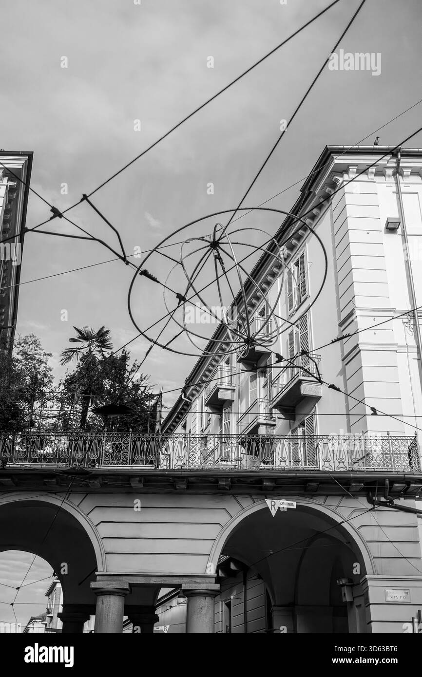 Schwarzweiß-Foto eines klassischen Gebäudes mit kunstvollen Bögen und Balkonen in Turin, mit Straßenbahnkabeln am Himmel. Hochwertige Pho Stockfoto