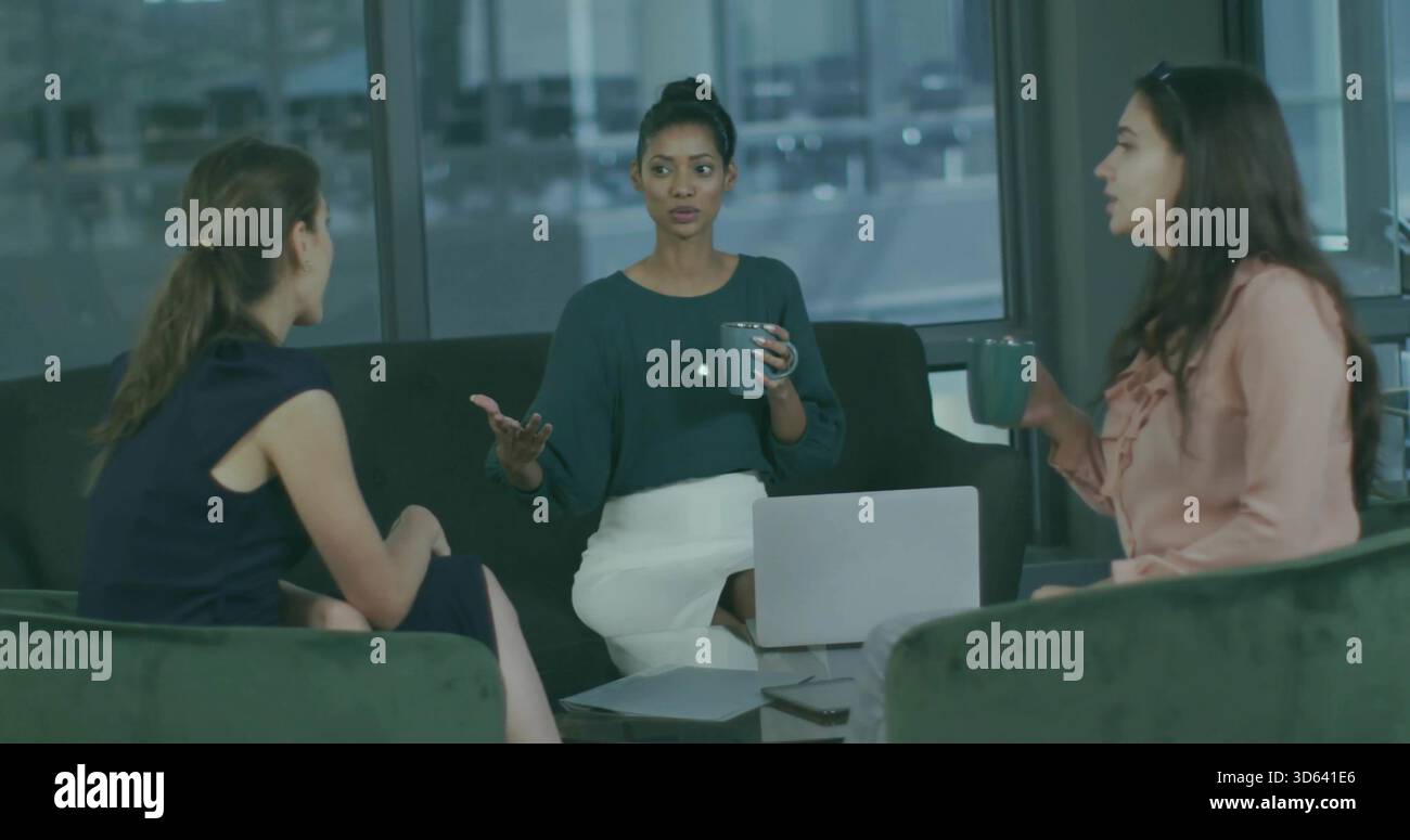Frau mit Gesten, grüne Bluse, weißer Rock, Leitung eines Meetings in der Bürolounge mit Laptop-Tassen Stockfoto