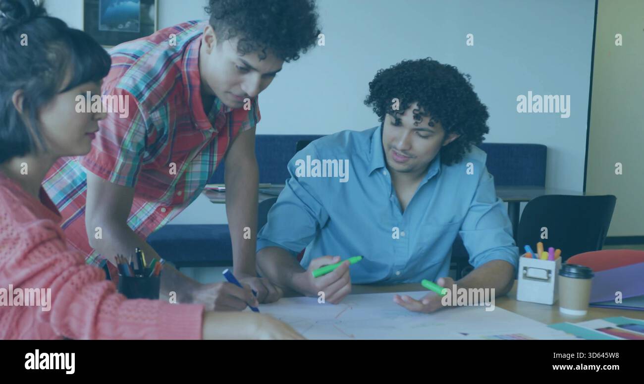 3 Studenten, die sich über den Meetingtisch lehnen, Frau in rosa Pullover, Mann mit grünem Textmarker Stockfoto