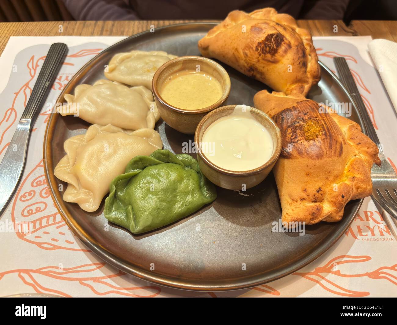 Gebackene Pierogi auf Teller im traditionellen Danziger Restaurant, Polen, mit Knödeln mit Käse- und Kartoffelfüllungen. Stockfoto