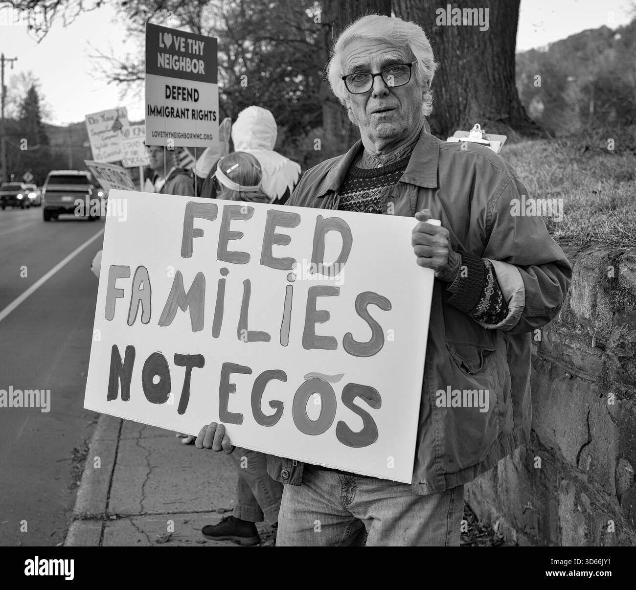 Anti-Trump-Demonstration in Ashville, North Carolina. Demonstranten mittleren Alters treffen sich jeden Donnerstag um 17 Uhr und halten Plakate für vorbeifahrende Autos aus . Stockfoto