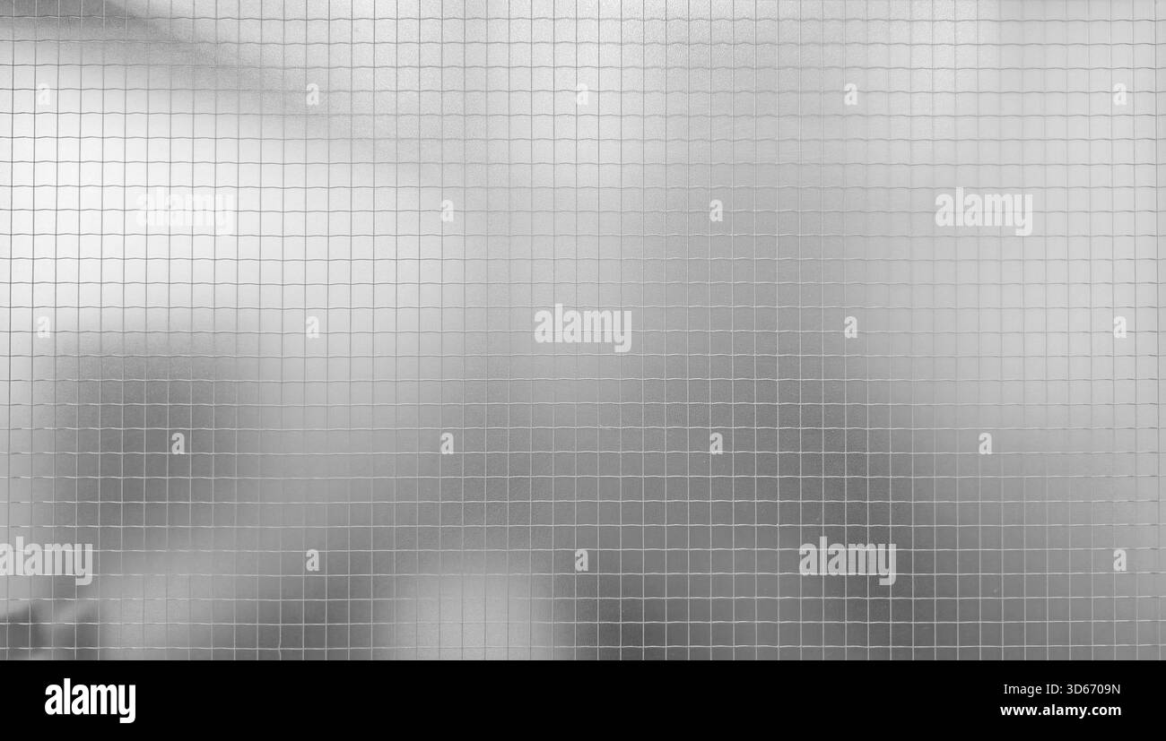 Graue, mattierte oder geätzte Glasoberfläche mit digitaler Textur und einem überlagernden feinen Gittermuster. Der Hintergrund hinter dem Glas ist leicht verschwommen und verschwommen Stockfoto