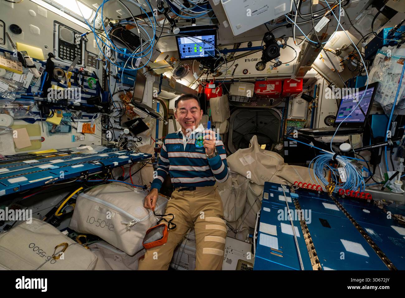ISS - 27. September 2025 - der Astronaut und Flugingenieur Kimiya Yui der JAXA (Japan Aerospace Exploration Agency) der Expedition 73 lächelt nach einem Porträt, nachdem er während der Hausreinigung am Wochenende im Harmony-Modul der Internationalen Raumstation einen verlorenen Stift gefunden hat - Foto: Geopix/NASA/Jonny Kim Stockfoto