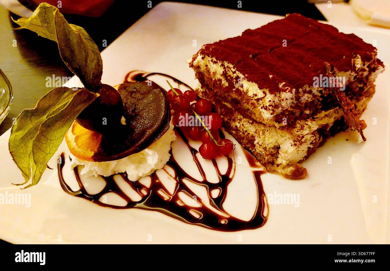 Luxemburg traditioneller Kuchen Dessert Schokolade mit cremiger Mousse gemischt mit getrockneter Orangenscheibe mit Schlagsahne und Schokoladensirup Stockfoto
