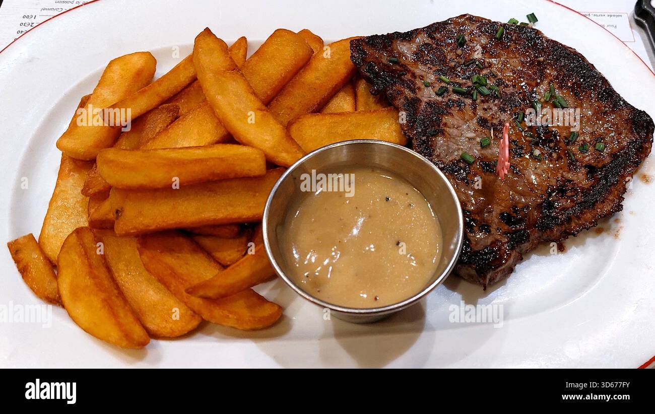 Steak mit dicken Pommes frites, serviert mit Soße aus schwarzem Pfeffer Stockfoto