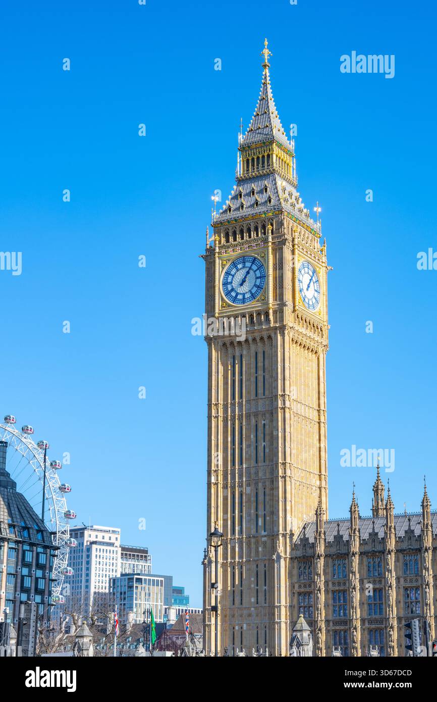 Der große Ben-Turm mit seinem detaillierten Zifferblatt und seiner goldenen Fassade steht hoch neben dem gotischen Palast von Westminster, mit teilweise sichtbarem London Eye. Stockfoto