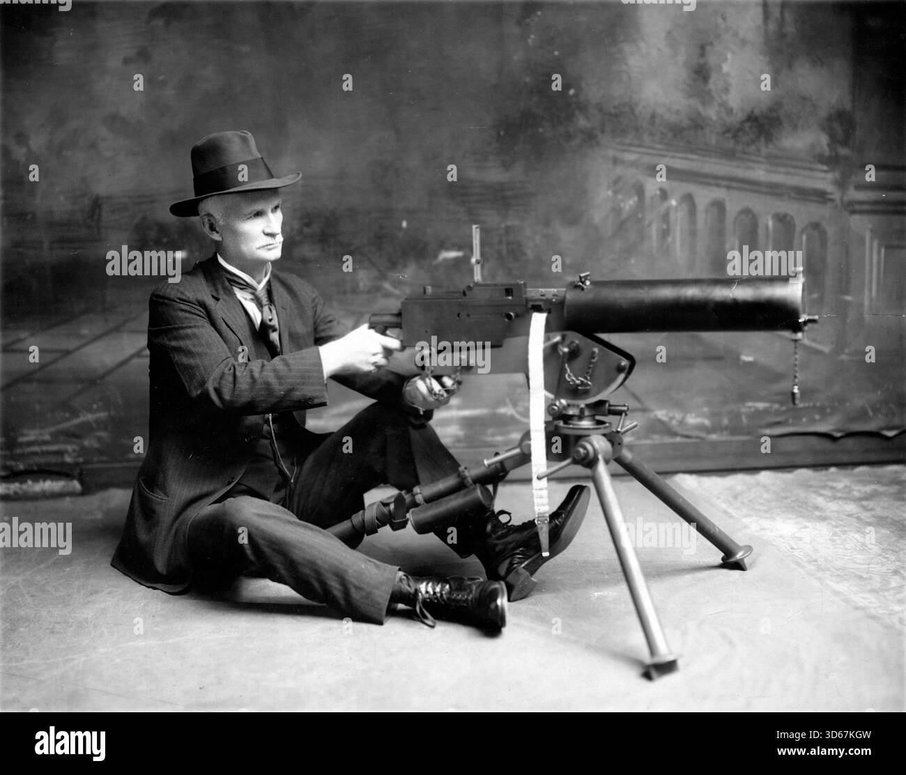 USA – um 1900 – Studio-Porträt des US-amerikanischen Erfinders John Moses Browning ( 1855-1926), posiert mit einer M1917 Browning Machine Gun. John Moses Browning wurde 1855 als Sohn eines Waffenschmieds im Utah-Territorium geboren und gehört zu den produktivsten Erfindern der Vereinigten Staaten. Er hielt 128 einzigartige Patente und entwarf über 100 verschiedene Geschütze, von Pistolen über Gewehre bis hin zu Maschinengewehren. Viele moderne Schusswaffen verwenden noch Mechanismen, die er entworfen hat, und einige seiner Entwürfe sind noch in Gebrauch - Foto: Geopix Stockfoto