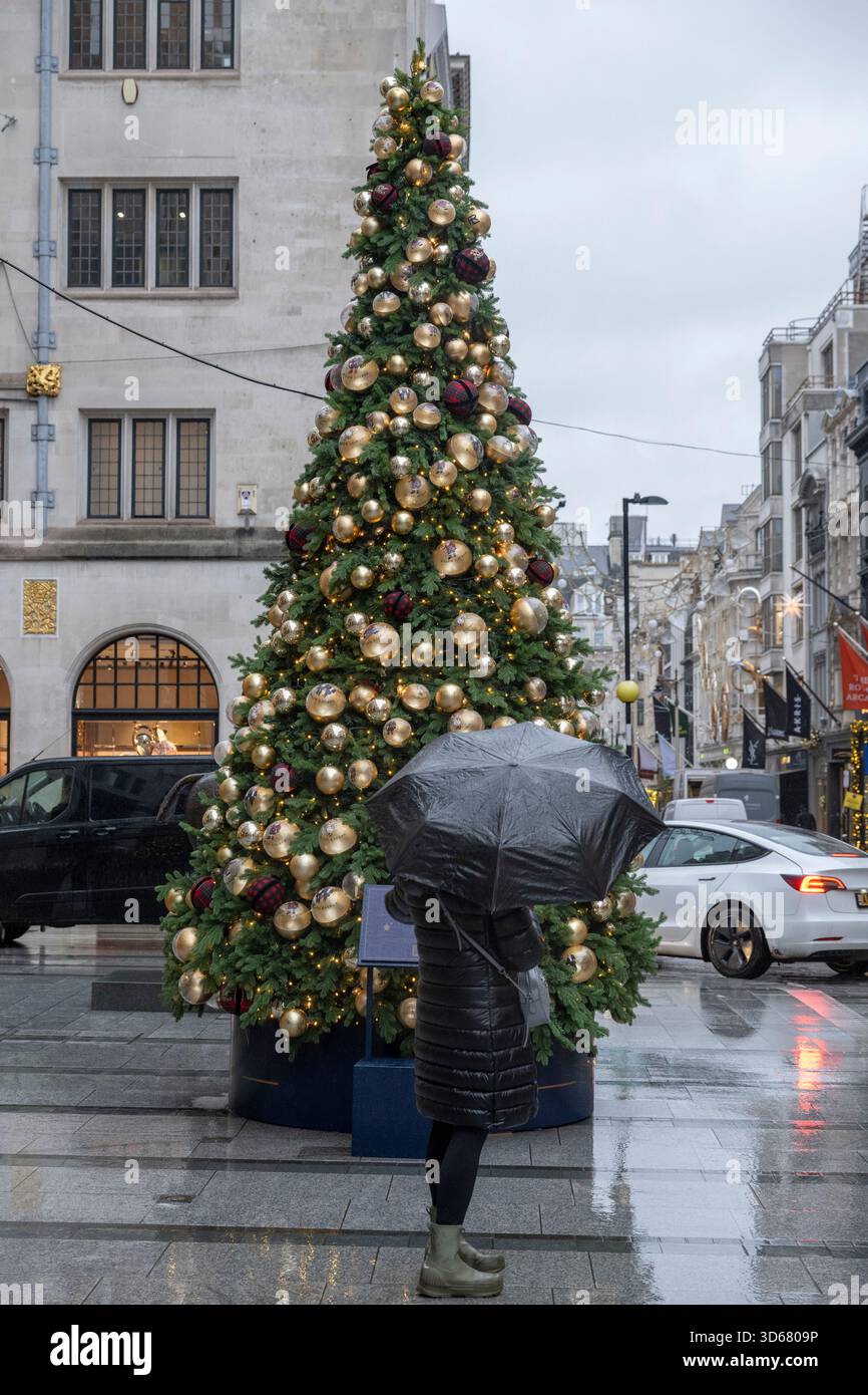 New Bond Street, London, Großbritannien. November 2025. Kälte und Schneeregen in Mayfair bei grauem Wetter mit farbenfrohen Geschäften, die zu Weihnachten 2025 dekoriert sind. Quelle: Malcolm Park/Alamy Live News Stockfoto