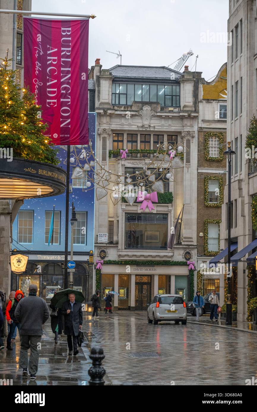 New Bond Street, London, Großbritannien. November 2025. Kälte und Schneeregen in Mayfair bei grauem Wetter mit farbenfrohen Geschäften, die zu Weihnachten 2025 dekoriert sind. Quelle: Malcolm Park/Alamy Live News Stockfoto